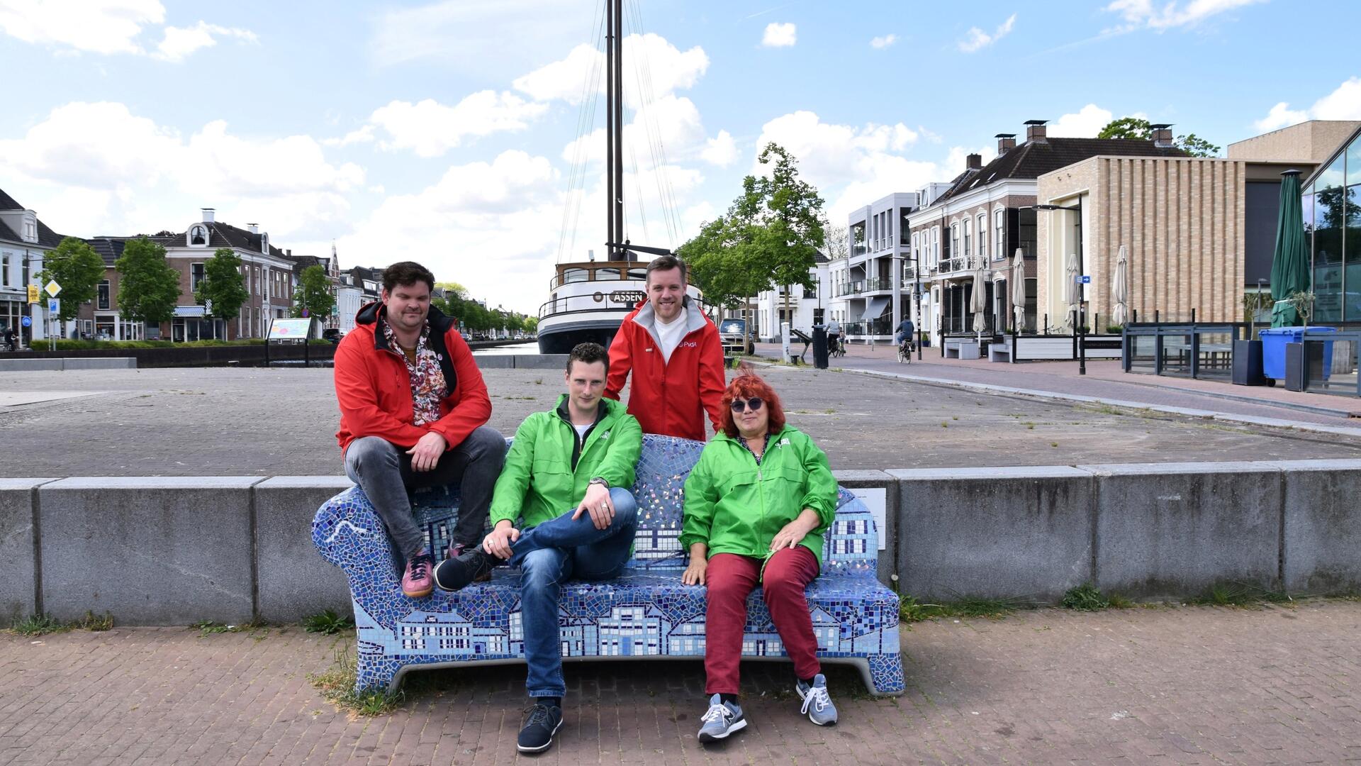 Op de foto, Ria Haan, Willard Bouwmeester, Peter de Vries en Jaap Veldhuizen, zittend op een bankje aan de kop van de vaart in Assen.